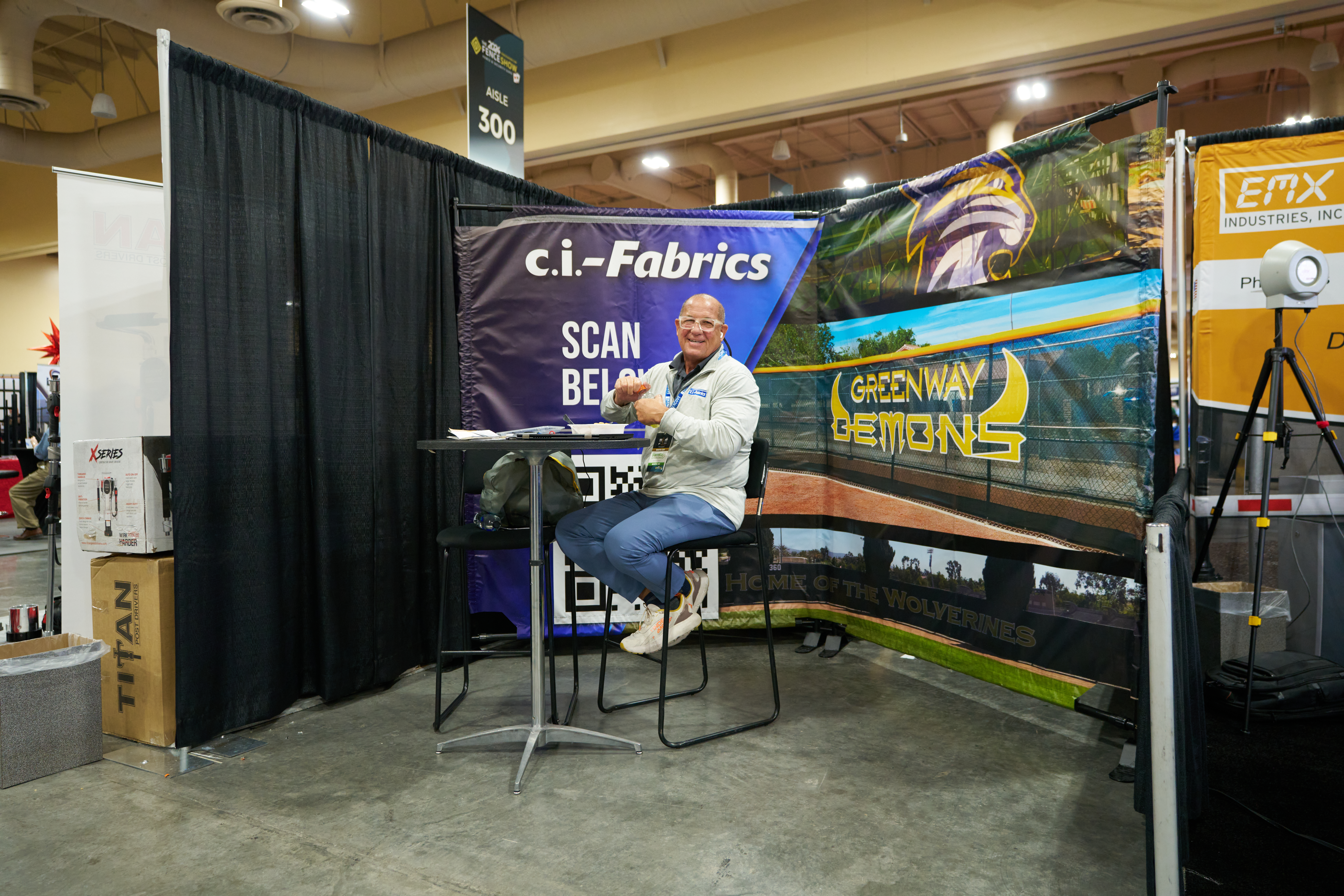 Ci-Fabrics, Inc. trade show booth showcasing fence screens, sports netting, banners, and installation examples.