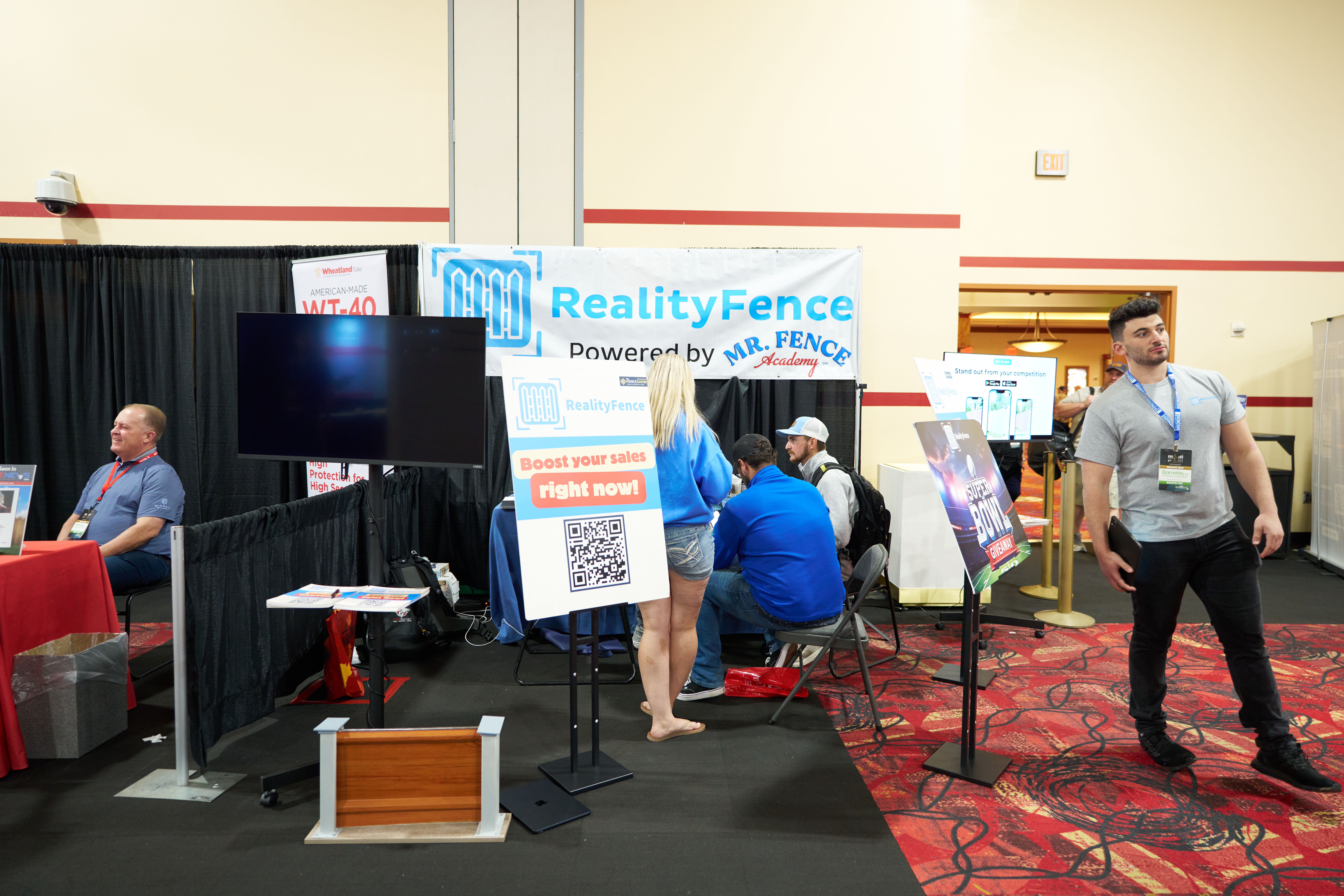Reality Fence trade show booth showcasing wood, vinyl, and aluminum fencing with installation examples and security solutions.